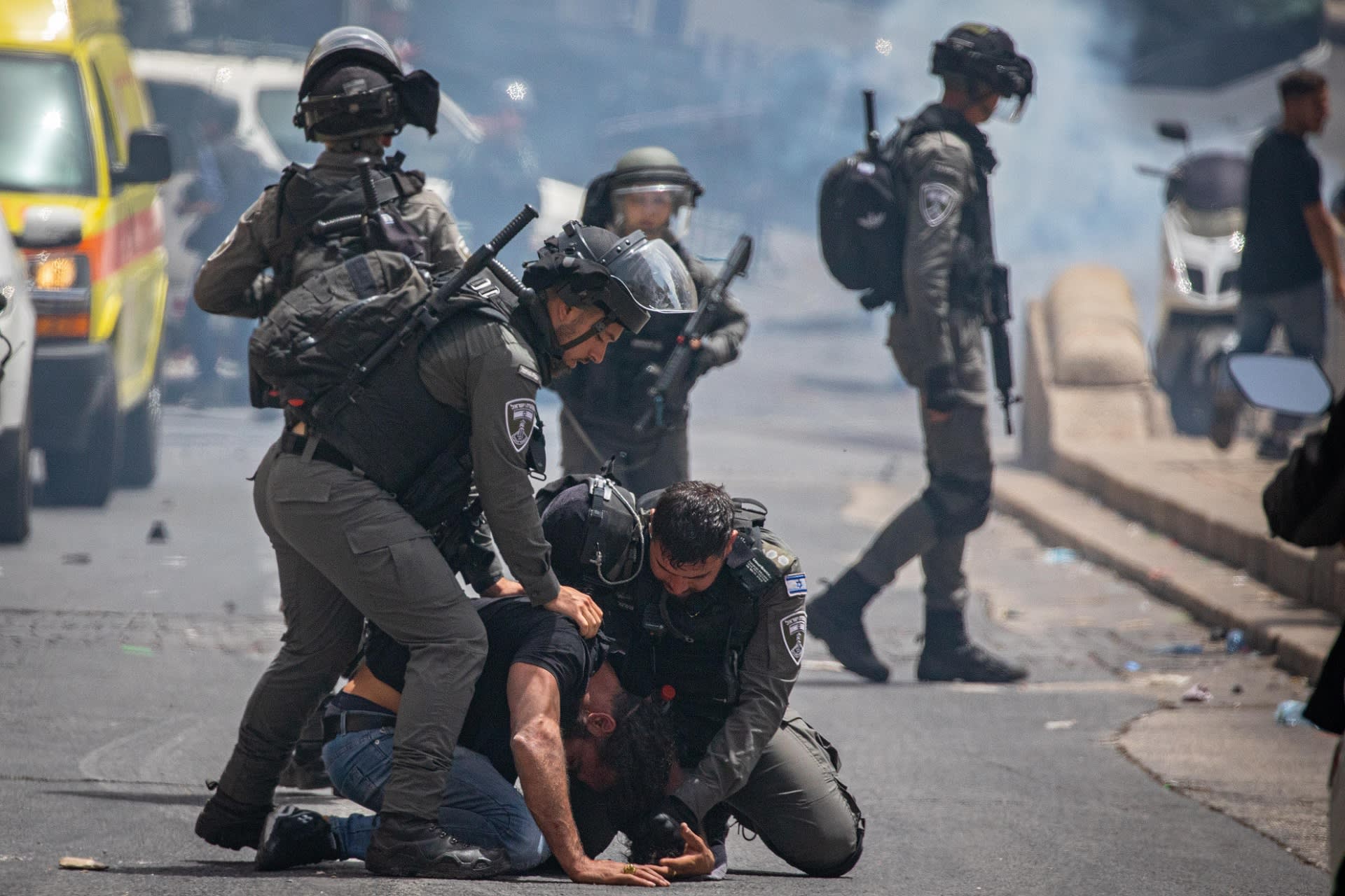 Kuvassa kaksi poliisia on painanut palestiinalaisen miehen katuun. 