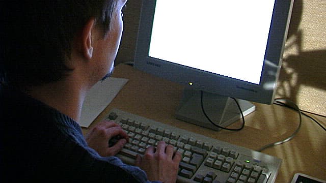Mies tietokoneen ääressä.