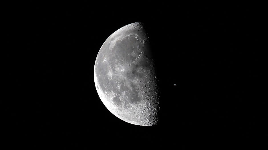 Kuu, ja sen ohitse lentävä kansainvälinen avaruusasema ISS kuvattuna Kennedyn avaruuskeskuksesta.
