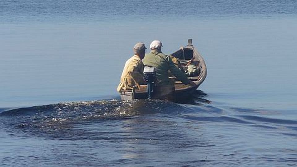 Kaksi miestä veneessä järvellä.