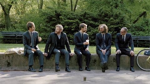 The National yhtyeen jäsenet istuvat puistossa.