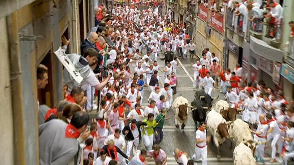 Juoksijoita ja härkiä Pamplonan kadulla.
