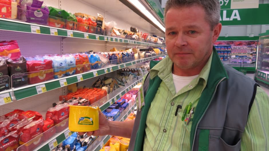 Kemin Prisman myyntipäällikkö Markku Juopperi juustopakkaus kädessään.