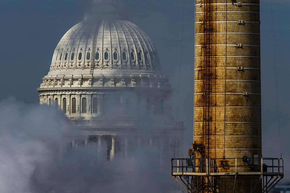 Savuinen näkymä Yhdysvaltain kongressin rakennukseen fossiilisia polttoaineita käyttävän voimalaitoksen takaa.