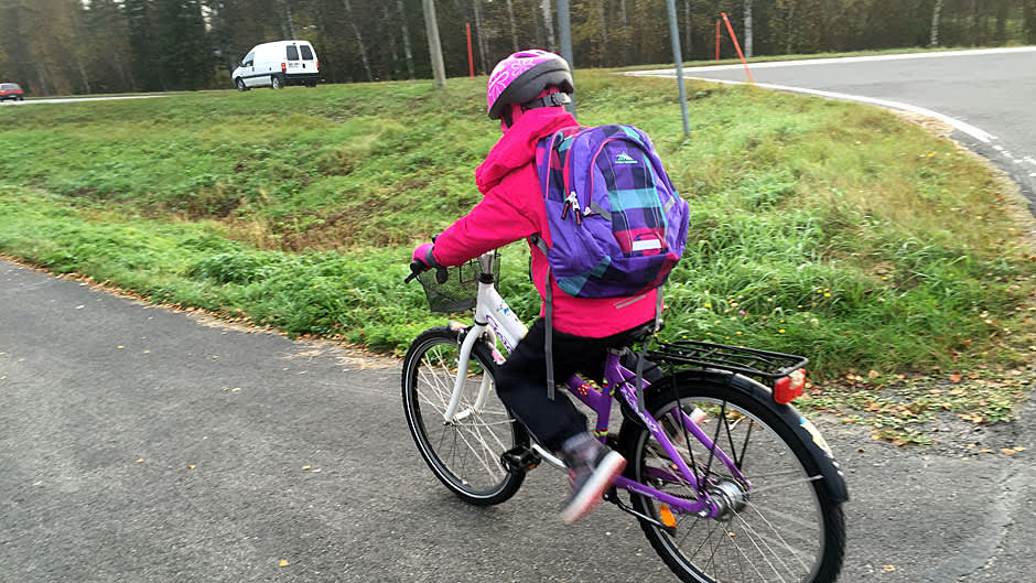 Lapsi pyöräilee kouluun.