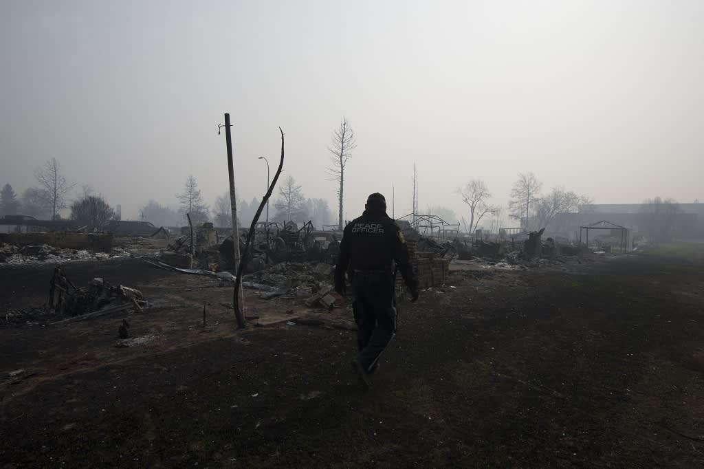 Mies kävelee palossa tuohoutuneella asuinalueella.