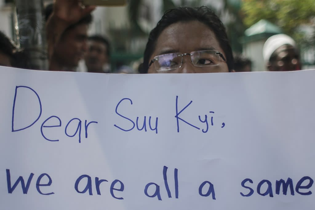 Mies pitelee kylttiä, jossa lukee: "Dear Suu Kyi, we are all a same."