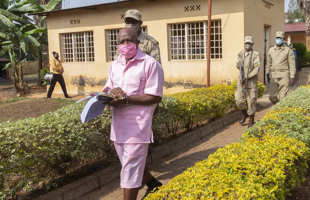 Kuvassa etualalla kävelee Paul Rusesabaguna vaaleanpunaisessa vangin asussa. Hänen takanaan kävelee kolme vartijaa. 