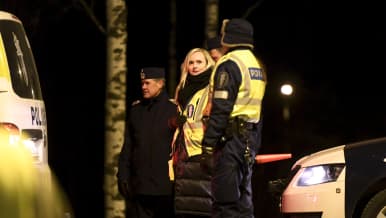 Keltaiseen poliisiliiviin pukeutunut Maria Ohisalo poliisin tarkistuspisteellä.