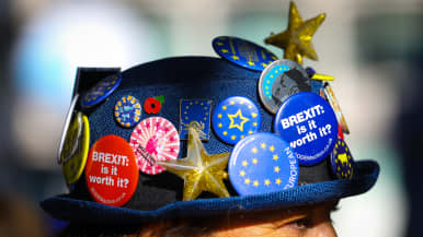 Mielenosoittajan hattu on täynnä brexitiä vastustavia rintamerkkejä.