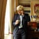 Boris Johnson toimistossa puhuen puhelimeen.