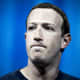 Facebooks grundare och vd Mark Zuckerberg med spänd min mot blå bakgrund.