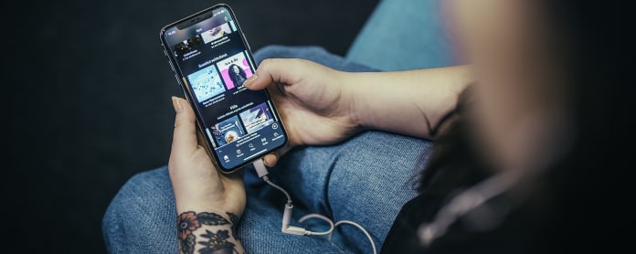 Puhelin kädessä sohvalla, Spotify auki.