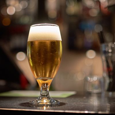 Beer in a stemmed glass on a bar.