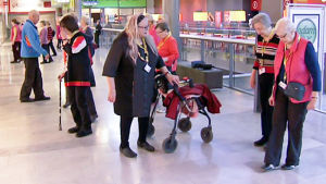 Annaliisa Lamminmäki osallistuu liikuntahetkeen rollaattorin avustuksella. Annaliisa Lamminmäki, kauppakeskuskävely,