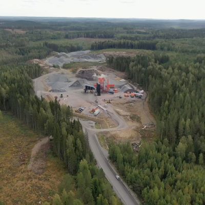 Metsän keskellä oleva asfalttiasema ilmasta kuvattuna