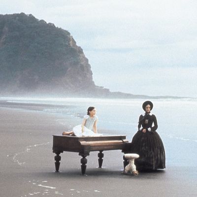 Nainen ja tyttö ja piano autiolla rannalla. Kuva elokuvasta Piano.