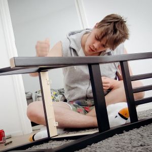 Väinö kokoaa tuolia uuden asuntonsa lattialla.