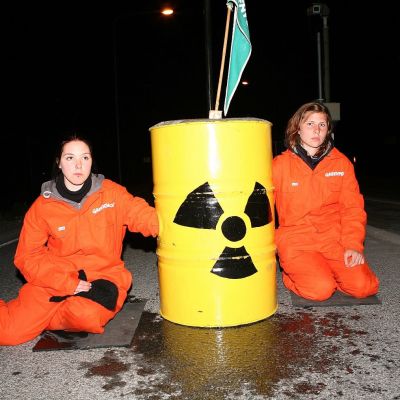 Två orangeklädda demonstranter utanför kärnkraftverksområdet i Olkiluoto i maj 2007.