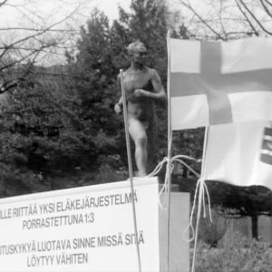 Protestimarssija Arvo Saarisen vaatimuslista Paavo Nurmen patsaan edessä.