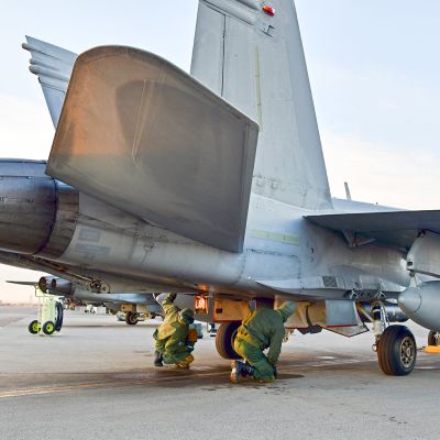 Lentotekniikan henkilöstö valmistelee ilmavoimien Hornetia tehtävälle koneen moottoreiden jo
käydessä.