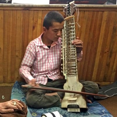 Nazim, tolv år, får undervisning i Dilruba, ett afghanskt nyckelharpsliknande instrument.