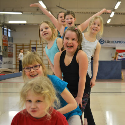 Aerobic-tytöt nauravat jonossa.