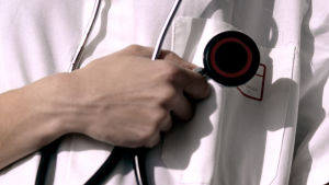 En läkare som håller i ett stetoskop.