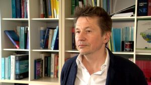 Alex Housen är professor vid Vrije Universiteit i Bryssel. Professor Alex Housen fotograferad i sitt arbetsrum i Bryssel. I bakgrunden syns en bokylla med facklitteratur.