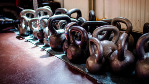 Med en kettlebell kan man göra många olika övningar. Bild på flera kettlebells