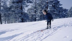 Redan som barn var Pekka Lundmark ute i skidspåret så ofta han kunde. Pekka Lundmark som barn åker skidor i en backe.