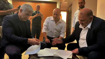 Yair Lapid, Naftali Bennett och Mansour Abbas (från vänster till höger) då de undertecknade koalitionsöverenskommelsen strax före nattens tidsfrist den 2 juni. Abbas leder ett av Israels arabiska partier.