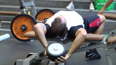 En ung man lyfter tyngder på gymmet.