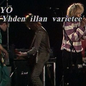 Kuvassa teksti "YÖ: Yhden illan varieteé" ja kolme yhtyeen jäsentä lavalla.