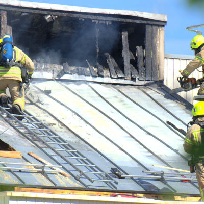 Räddningstjänsten tvingas såga upp taket för att komma åt brandhärden.