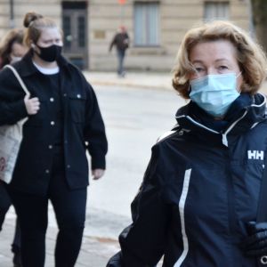 En kvinna går på gatan med munskydd.