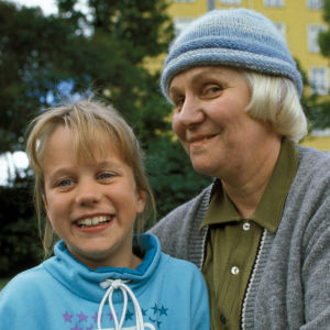 Sarjan Mummo Anna ja mummi lähikuvassa. Istuvat puistossa kesällä ja katsovat kameraan.