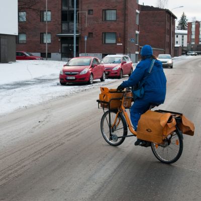 Postinjakaja ajaa pyörää Kuopiossa.