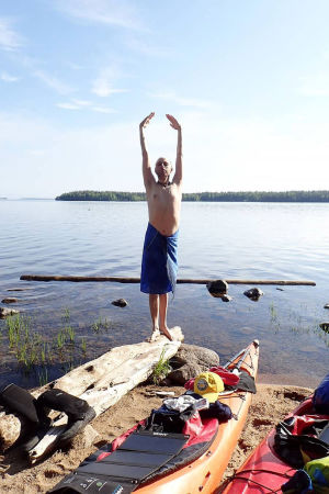 Christoffer Leka yogar vid Uikujärvis strand. Christoffer Leka yogar vid strandkanten någonstans i Karelen.
