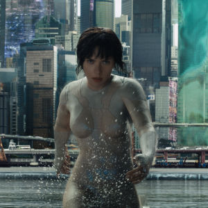 Major (Scarlett Johansson) springer i vatten, i bakgrunden skyskrapor.