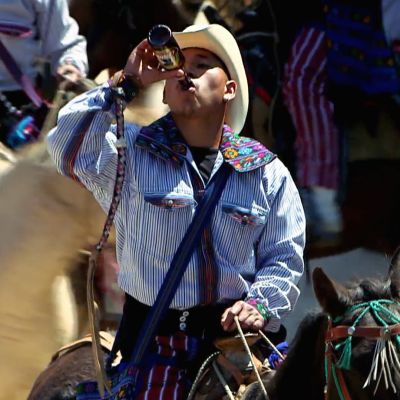 Mies juo olutta pullosta hevosen selässä.
