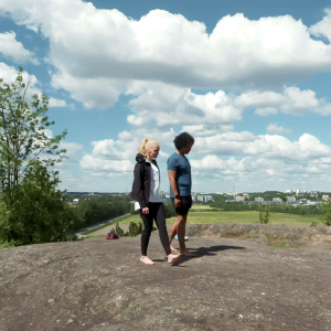 Annastiina Hintsa ja Sean Ricks kävelevät kalliolla paljain jaloin. 