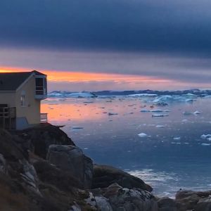 Ett hus på en klippa vid ett ishav.