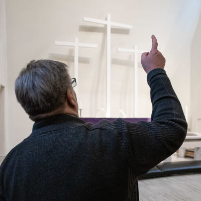 Kiinteistöpäällikkö Jari Nousiainen osoittaa Kolmen ristin kirkon alttaria johon aamu auringon säteet osuvat.
