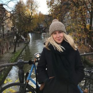 Vasabördiga Michaela Lipkin fotograferad i ett höstligt Utrecht med pittoreska kanaler och höstliga träd i bakgrunden. 