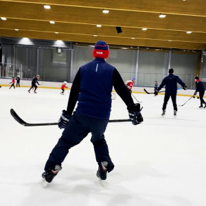 Flera ishockeyspelare med klubba och handskar men som hobbyspelare saknar de övriga skydd.