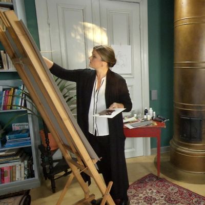 Camilla Forsén-Ström målar vid staffli.