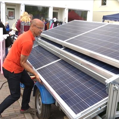 André Lindholm öppnar solpanelerna på Pargas mobila solvagn.