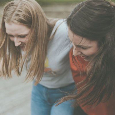 Artikkelikuva Abitreenien artikkeliin. Kuvassa kolme nuorta naista nojaa toisiinsa ja nauraa.