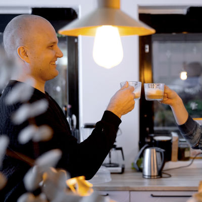 kaksi iloista miestä juo kahvia työpaikan viihtyisässä taukotilassa